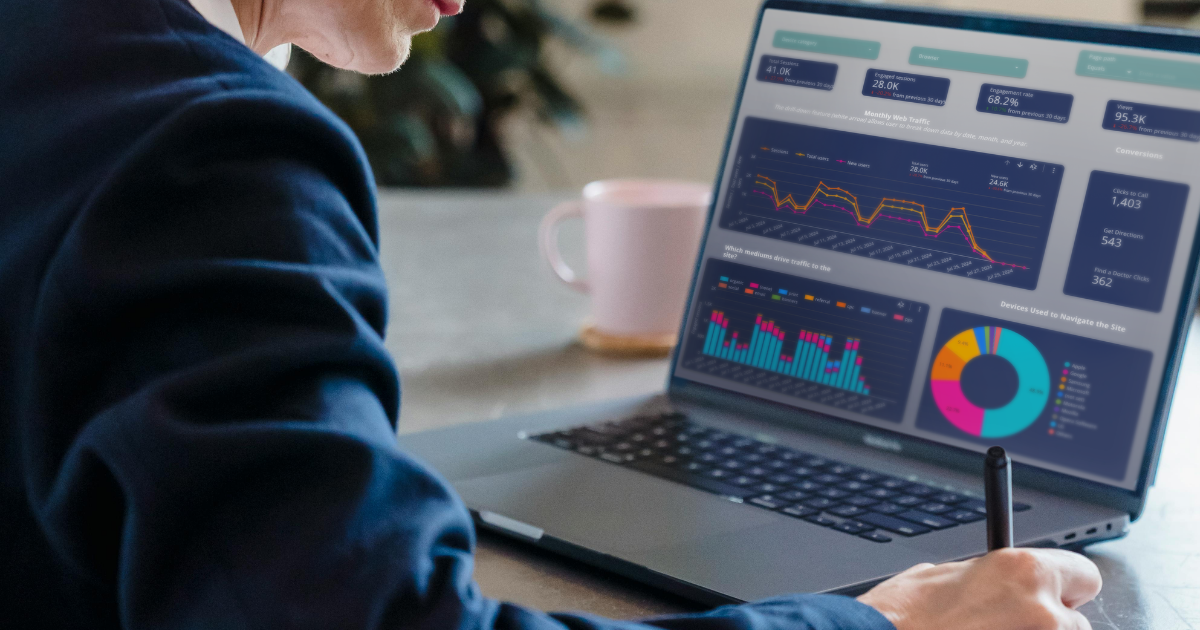 A woman is taking notes after reviewing a data analytics dashboard.
