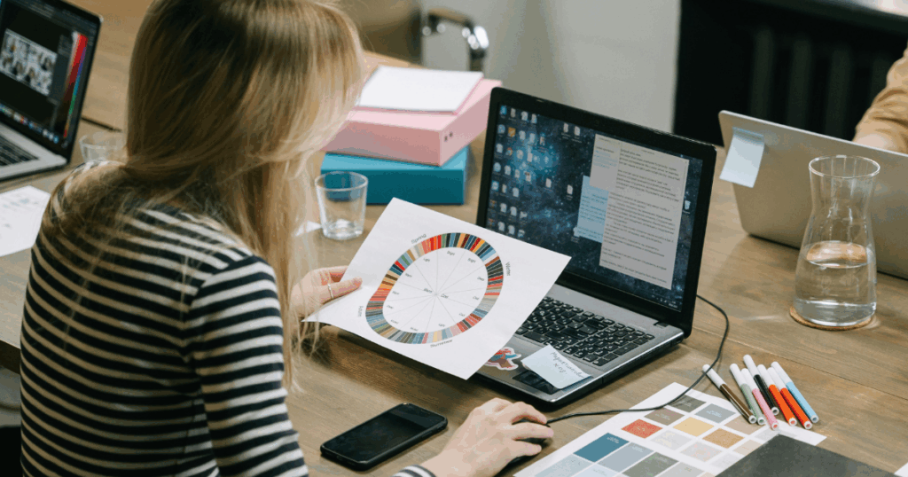 woman looking at a color wheel and her laptop